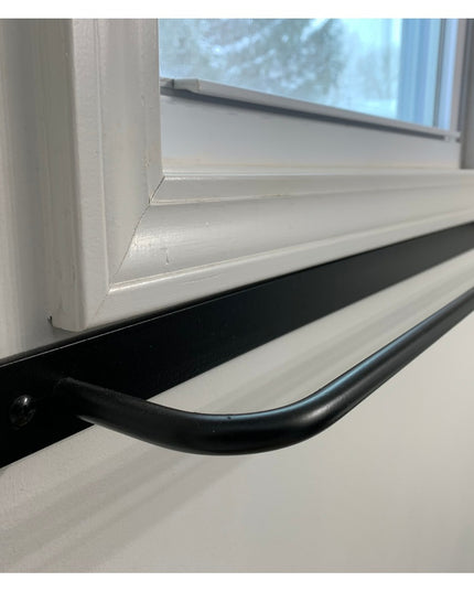 The Oswego Modern Bathroom Towel Bar by Industrial Farm Co in matte black finish mounted below white window frame