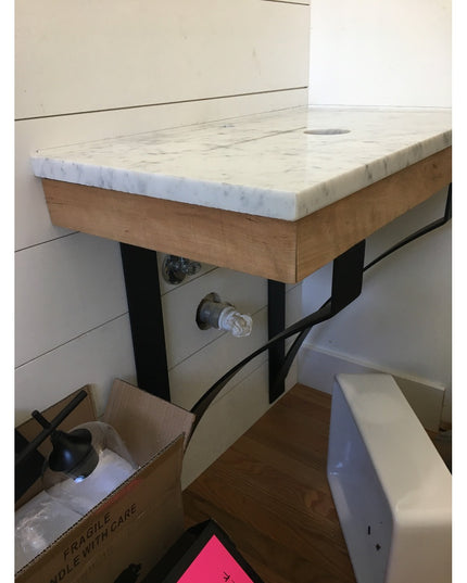 Black metal Rochester countertop brackets supporting white marble surface with wood base, Industrial Farm Co desk support ...