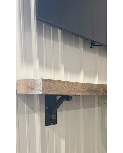 Black metal Rosamond shelf bracket supporting rustic wood beam against white shiplap wall by Industrial Farm Co
