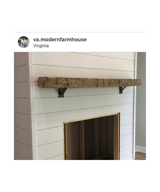 Rustic reclaimed wood mantel shelf with black metal Troy Shelf Support brackets mounted above white shiplap fireplace surr...