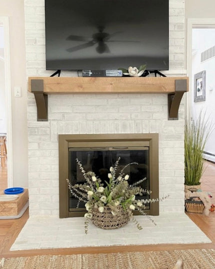 Norfolk Farmhouse Bracket by Industrial Farm Co supporting rustic wood mantel above white brick fireplace in modern living...