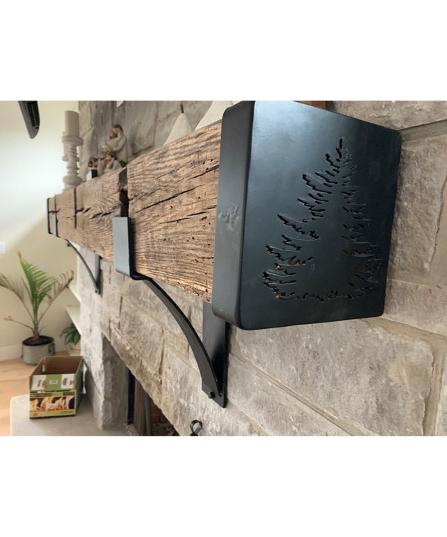 Black metal Vandiver Evergreen Tree Mantel End Caps with fern cutout design mounted on rustic stone fireplace mantel by In...