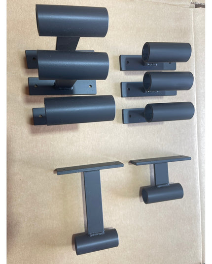 Black metal wall mounting brackets and ladder rungs for Industrial Farm Co Wall Mounted Ossit Ladder system laid out on be...