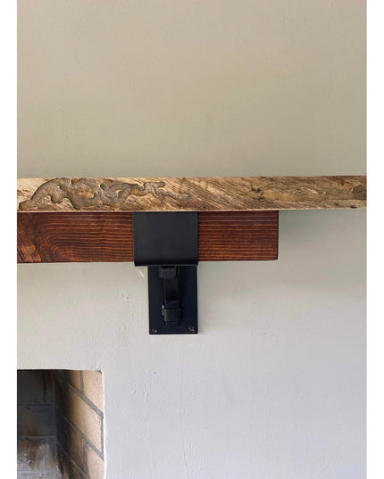 Heavy duty black steel Buffalo 4" mantel bracket supporting live edge wood beam on white wall, handmade USA by Industrial ...