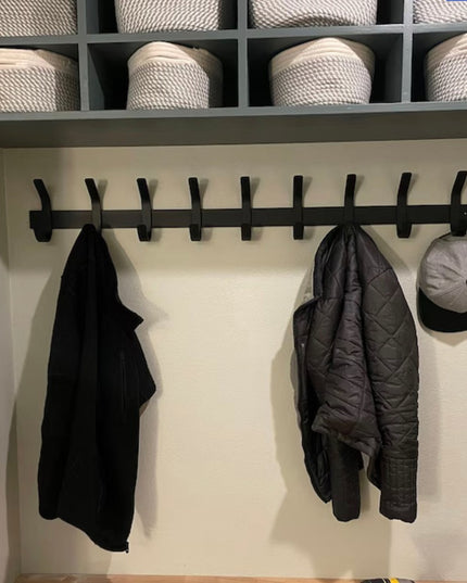 Black metal Christopher Double Hook Coat Rack by Industrial Farm Co mounted on white wall with jackets and hat hanging, st...