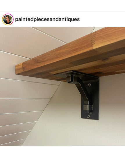 Black metal Rosamond shelf bracket supporting natural wood shelf against white shiplap wall by Industrial Farm Co