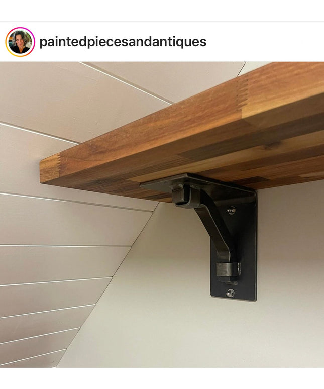 Black metal Rosamond shelf bracket supporting natural wood shelf against white shiplap wall by Industrial Farm Co