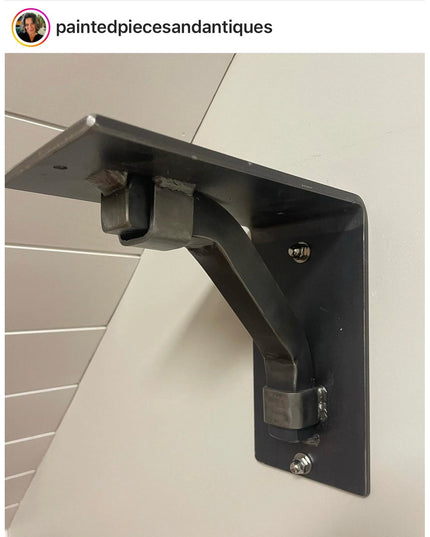 Black metal Rosamond shelf support bracket mounted on white shiplap wall showing industrial farmhouse design by Industrial...