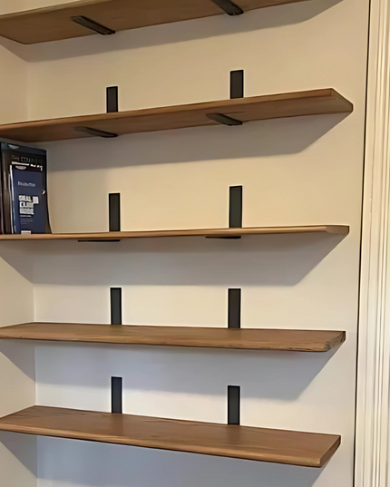 Wooden shelves on a wall with books on one of them.