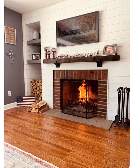 Dark walnut Norfolk Farmhouse Bracket supporting wooden mantel shelf above brick fireplace with white shiplap wall from In...