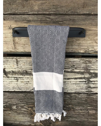 Black metal Oswego Modern Bathroom Towel Bar by Industrial Farm Co mounted on weathered wood with geometric patterned towel