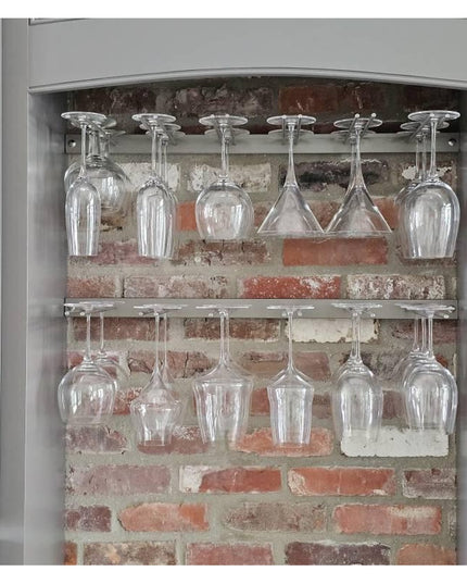 White Plains Wine Glass Rack by Industrial Farm Co displaying clear wine glasses on two tiers against exposed brick wall i...
