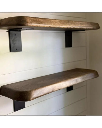 Heavy duty black steel L-bracket shelf supports holding thick walnut wood floating shelves against white shiplap wall - In...