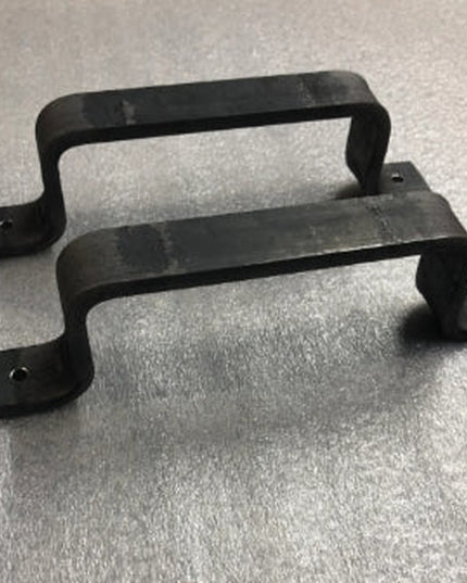 Black metal Sagamore Hill Pull door handles by Industrial Farm Co, two curved cabinet pulls with mounting plates on textur...