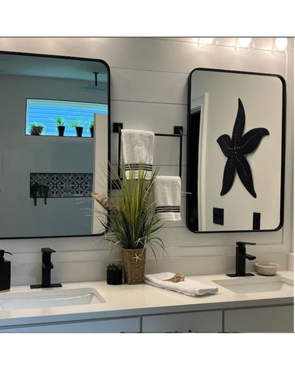Black metal starfish-shaped wall-mounted towel holder displayed in modern bathroom with dual vanity sinks and mirrors - Th...