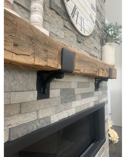 Black metal Buffalo 4" mantel brackets supporting rustic wood beam mantel on stone fireplace, handmade heavy duty steel co...