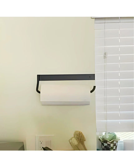 Black metal under-cabinet paper towel holder mounted on white kitchen wall with white subway tile backsplash and white pap...