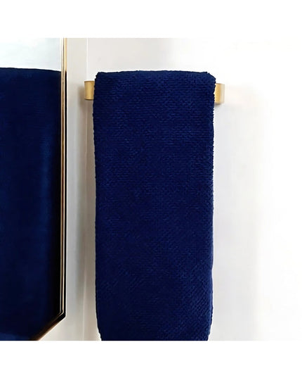 Navy blue towel hanging on brass Emma Towel Holder door pull by Industrial Farm Co mounted on white wall