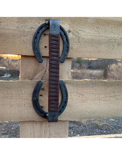 Bermuda Horseshoe Door Handle with brown leather wrap mounted on weathered wood fence by Industrial Farm Co