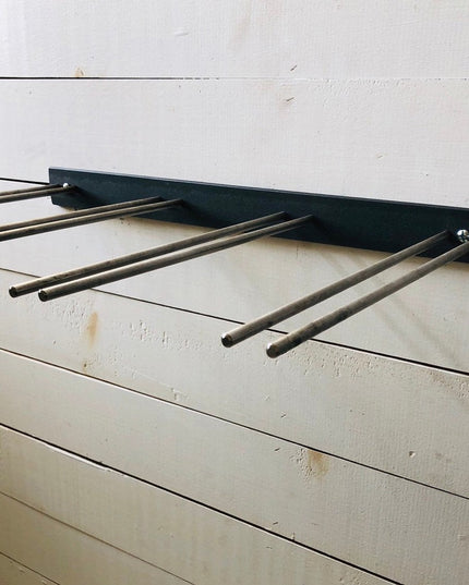 Black metal wine glass rack with four stemware holders mounted on white wooden wall displaying modern minimalist design by...