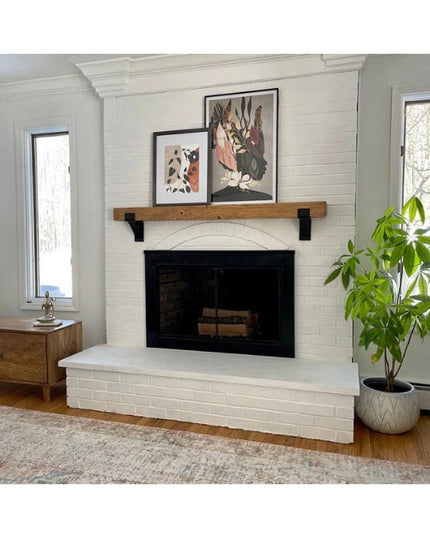 Natural wood Kudlick Farmhouse Mantel Bracket by Industrial Farm Co supporting rustic wooden mantel shelf above white bric...