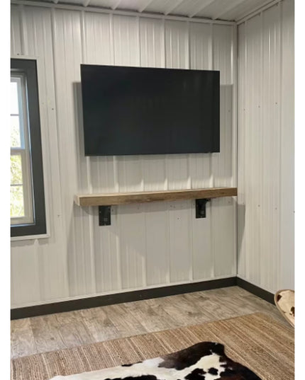 Black metal Rosamond Shelf Supports by Industrial Farm Co holding wooden floating shelf beneath wall-mounted TV in modern ...