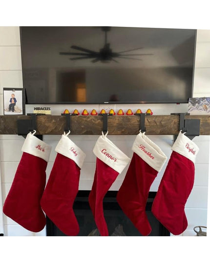 Industrial Farm Co Annie Stocking Holder displaying five red Christmas stockings with names on white fireplace mantel with...