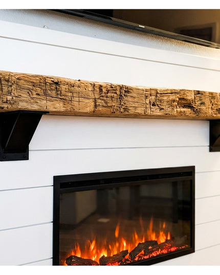 Heavy duty black steel industrial shelf brackets supporting rustic reclaimed wood mantel above white shiplap electric fire...