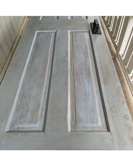 Black metal Corning Handle door pull mounted on weathered gray wood door by Industrial Farm Co, showing rustic farmhouse h...