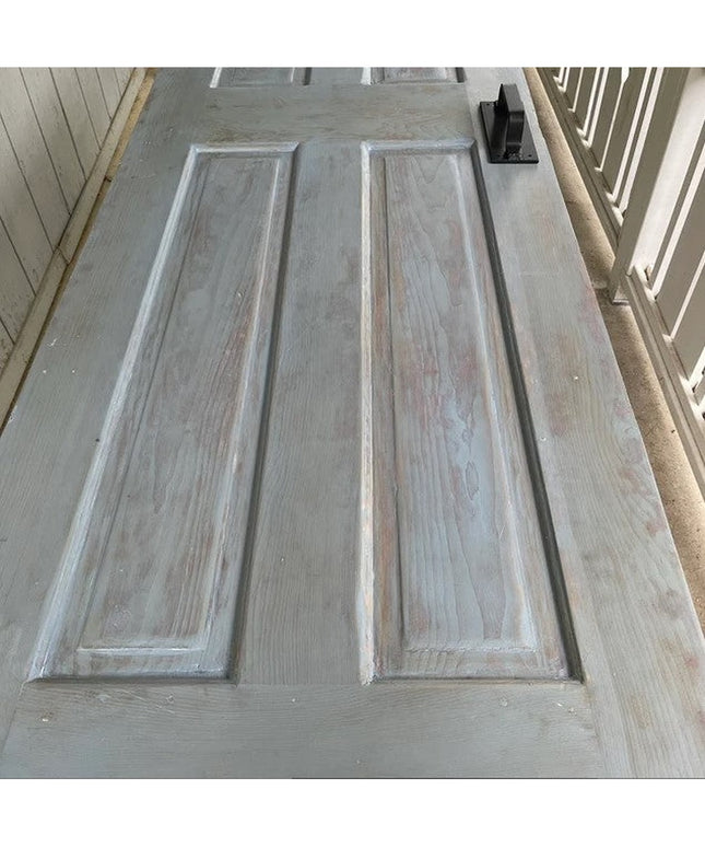 Black metal Corning Handle door pull mounted on weathered gray wood door by Industrial Farm Co, showing rustic farmhouse h...