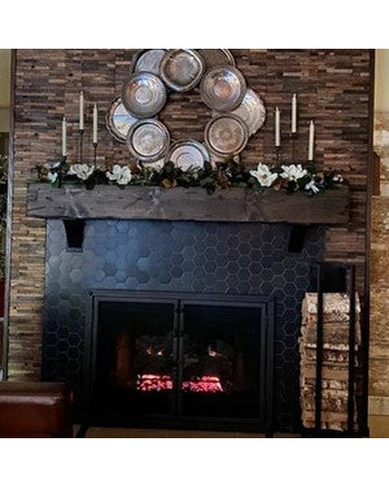 The Toby Firewood Holder by Industrial Farm Co in rustic brown wood displayed next to a stone fireplace with decorative pl...