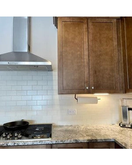 White under-cabinet paper towel holder mounted beneath kitchen cabinet with granite countertop and subway tile backsplash ...