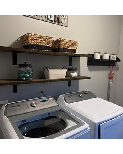 Black metal L-shaped shelf brackets supporting rustic wooden shelves in organized laundry room with white washer and dryer...