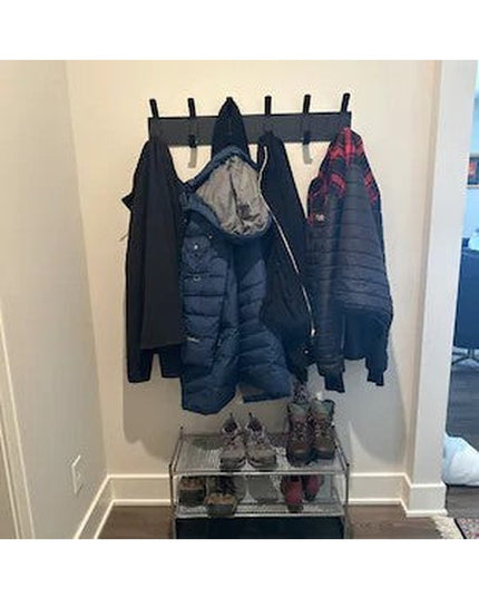 Riseform black metal wall mounted coat rack with 6 hooks holding winter jackets and coats, with shoe storage rack below in...