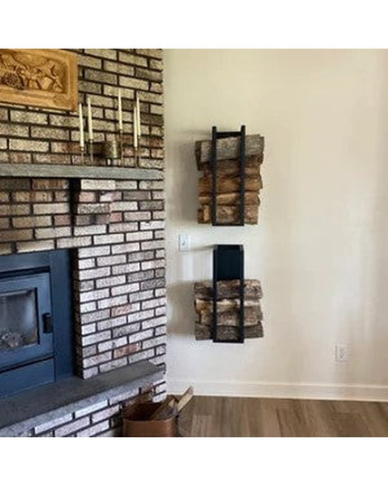 Black metal Toby Firewood Holder wall-mounted storage racks holding stacked logs next to brick fireplace by Industrial Far...