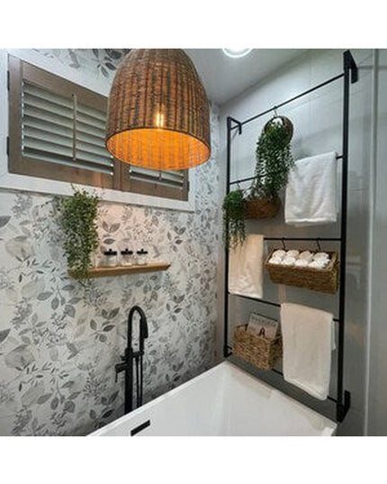 Black metal Veronica Modern Blanket Ladder by Industrial Farm Co displayed in spa bathroom with wicker baskets and towels