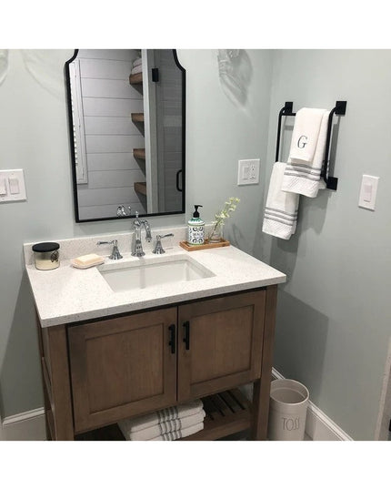 Black metal Parker Hand Towel Ladder by Industrial Farm Co mounted on bathroom wall holding white monogrammed towels in mo...