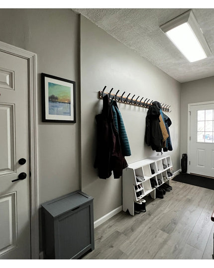 Black metal Christopher Double Hook Coat Rack by Industrial Farm Co mounted on mudroom wall with coats hanging, featuring ...