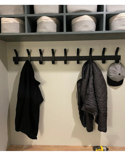 Black metal Christopher Double Hook Coat Rack by Industrial Farm Co mounted on wall with storage cubby above holding wicke...