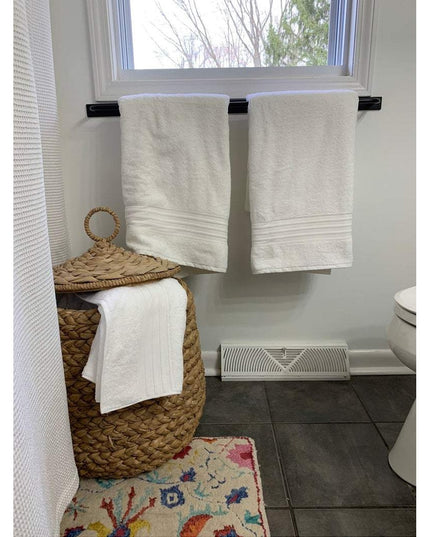 Black Oswego Modern Bathroom Towel Bar by Industrial Farm Co mounted under window with white towels hanging in bathroom