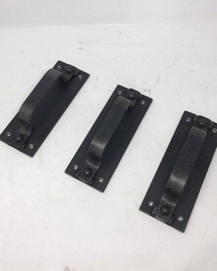 Three black metal Corning Handle door pulls by Industrial Farm Co arranged on white surface, showing rectangular mounting ...