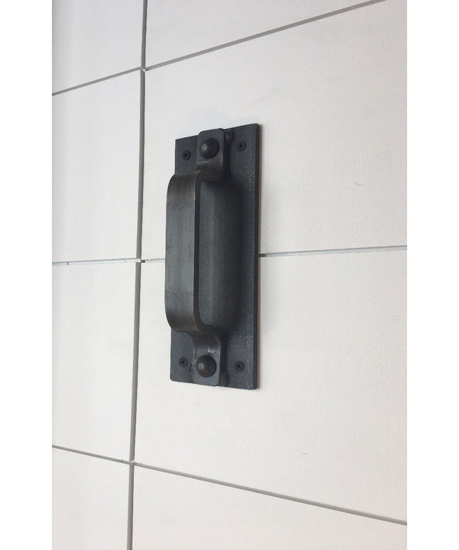 Black iron Corning Handle door pull mounted on white tiled wall, showing industrial farmhouse style hardware by Industrial...