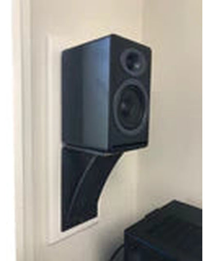 Black bookshelf speaker mounted on curved steel bracket against white wall, showing Industrial Farm Co Ninemile heavy duty...