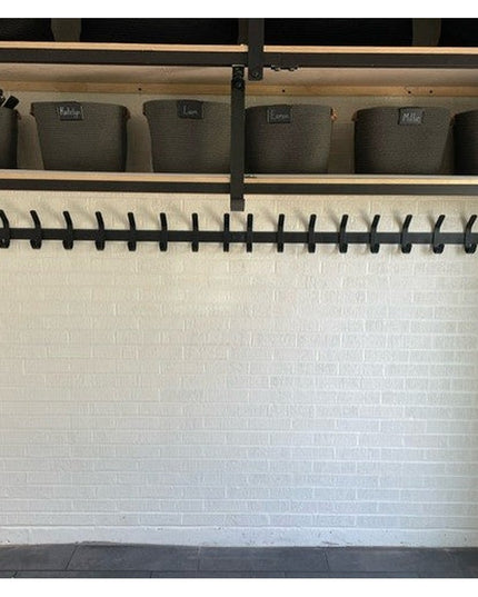 Black metal Christopher Double Hook Coat Rack by Industrial Farm Co mounted on white shiplap wall with storage bins above ...